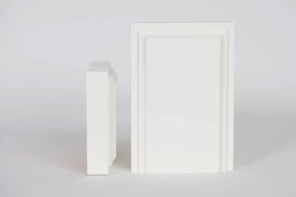 Två vita, rektangulära skivor stående bredvid varandra mot en grå bakgrund.