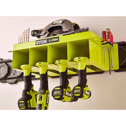 Grön verktygshylla med texten "RYOBI LINK", borr och skruvdragare förvarade under facken.