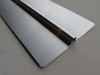 Aluminiumplåt med böjd kant på betongliknande bakgrund.