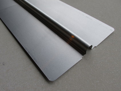 Aluminiumplåt med böjd kant på betongliknande bakgrund.