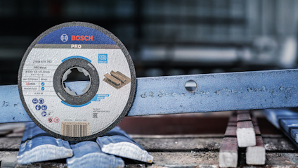 Slipsskiva Bosch Pro står lutad mot metallbjälkar.